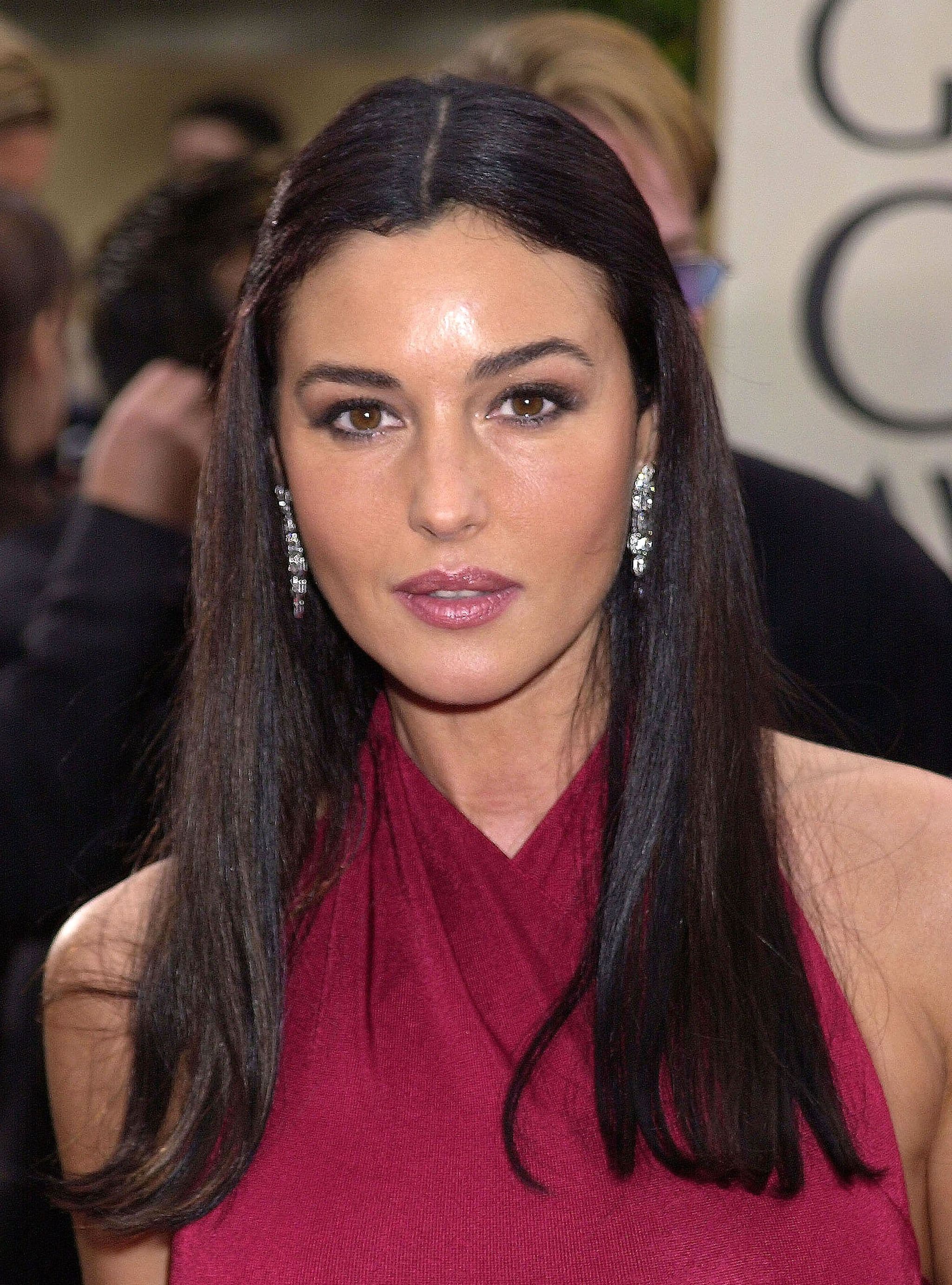 At the Golden Globes, Bellucci completes a magenta halter-neck dress with elaborate diamond drop earrings.