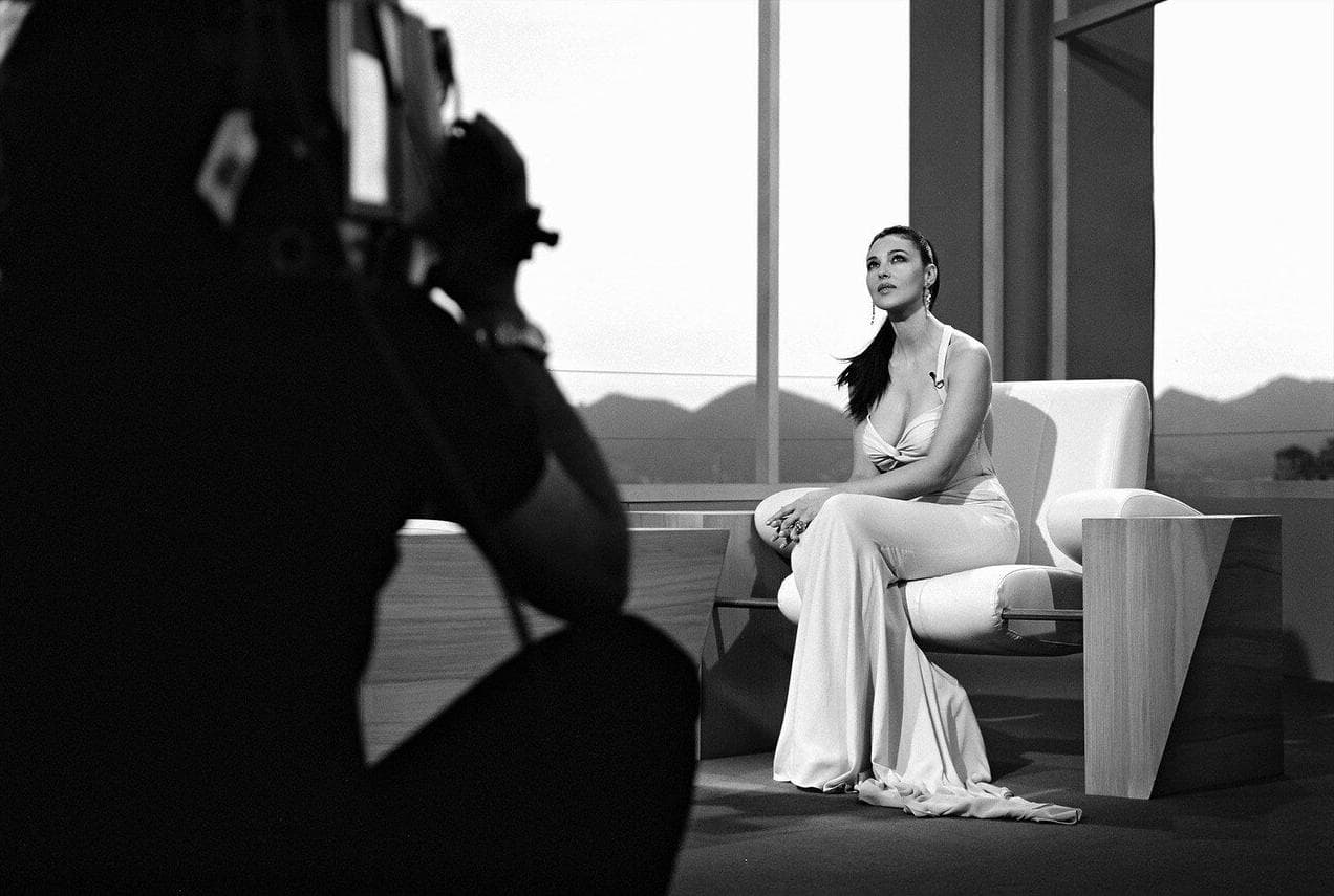 The festival host sits for a television interview in her flowing pale gown.