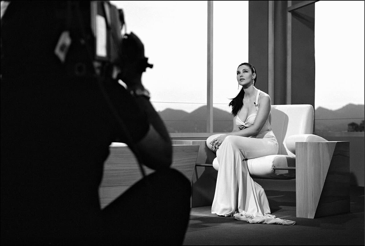 The festival host sits for a television interview in her flowing pale gown.