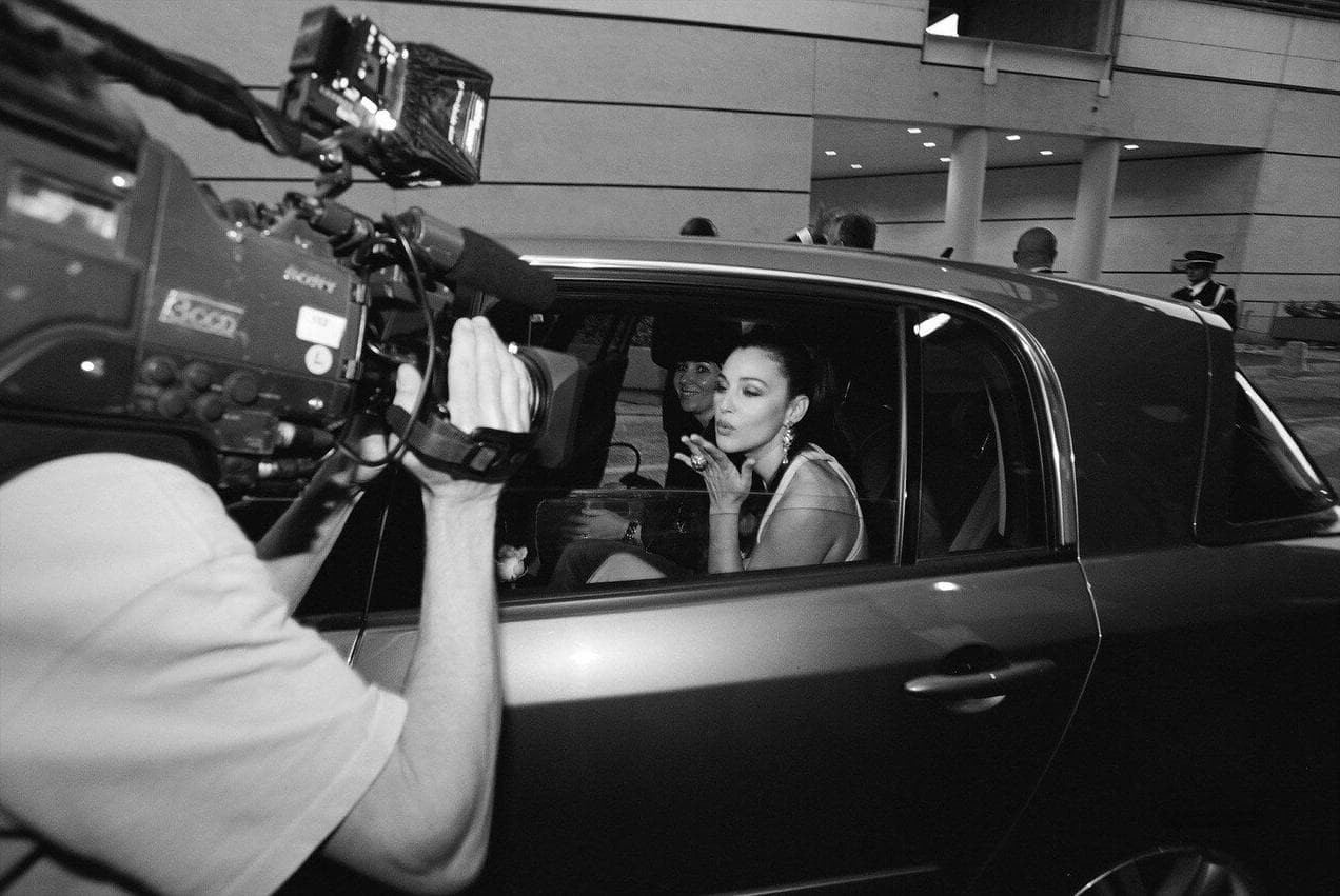 She blows a kiss to a television camera from her car during the festival.