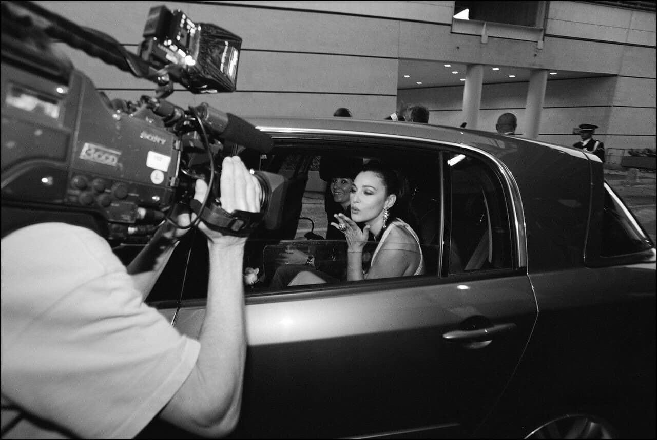 She blows a kiss to a television camera from her car during the festival.
