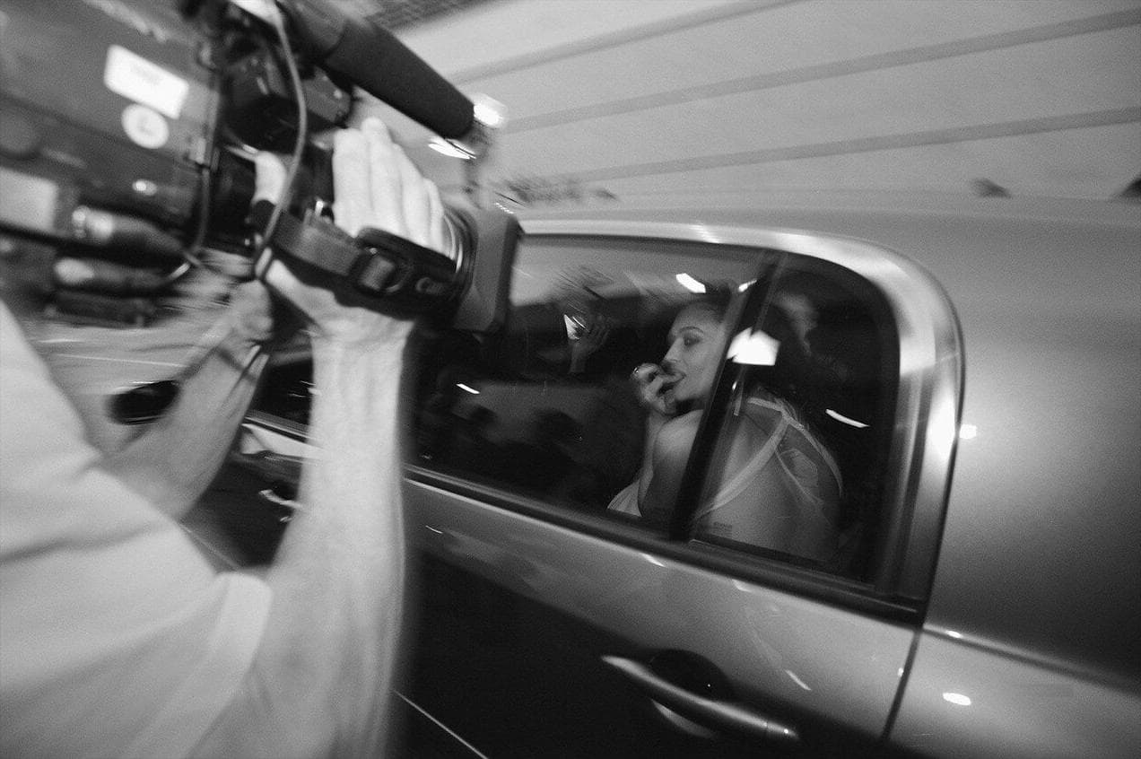 A camera follows Bellucci through the car window as she leaves a Cannes engagement.