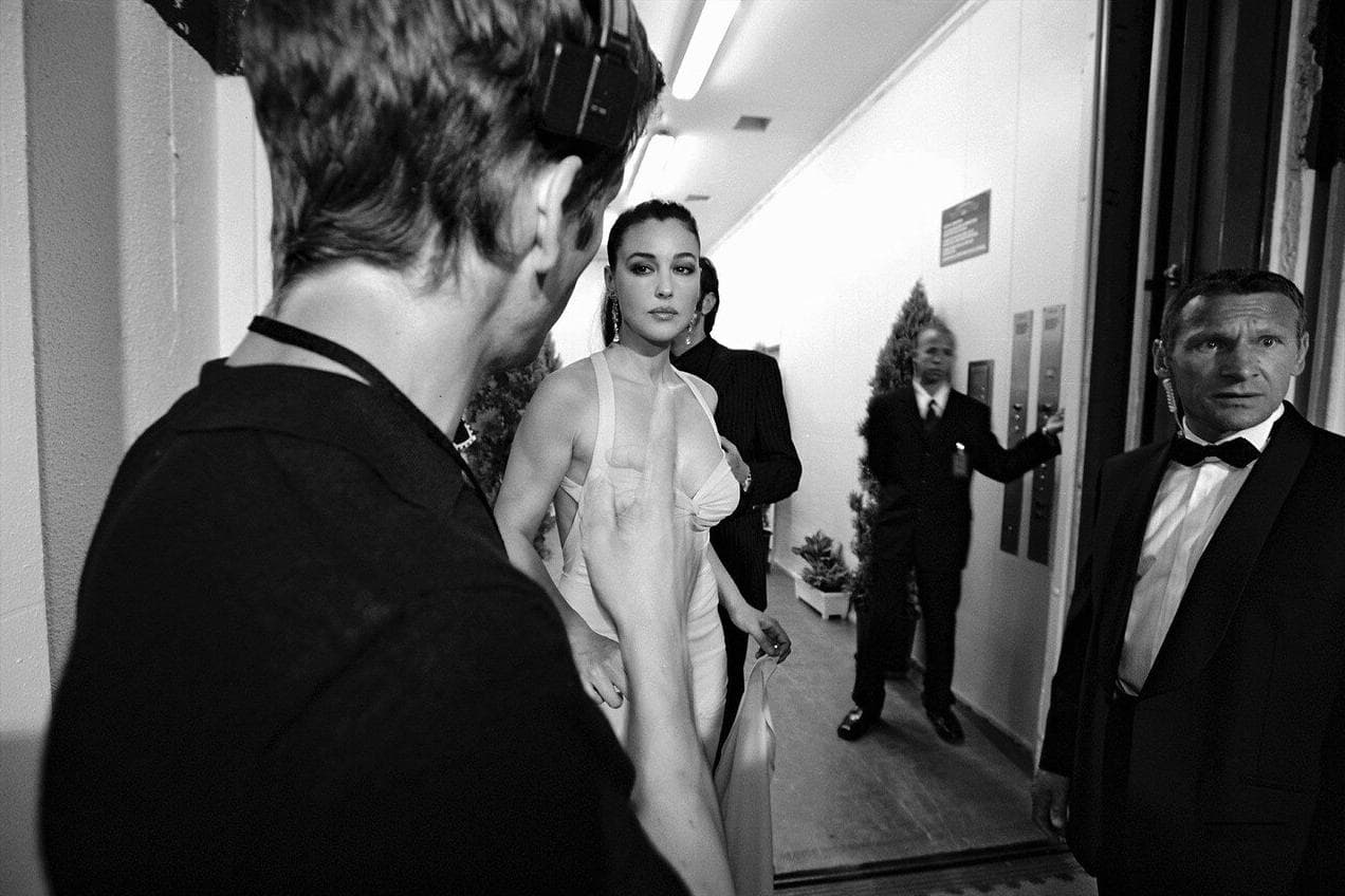 Bellucci steps from backstage toward the ceremony in her floor-length gown.
