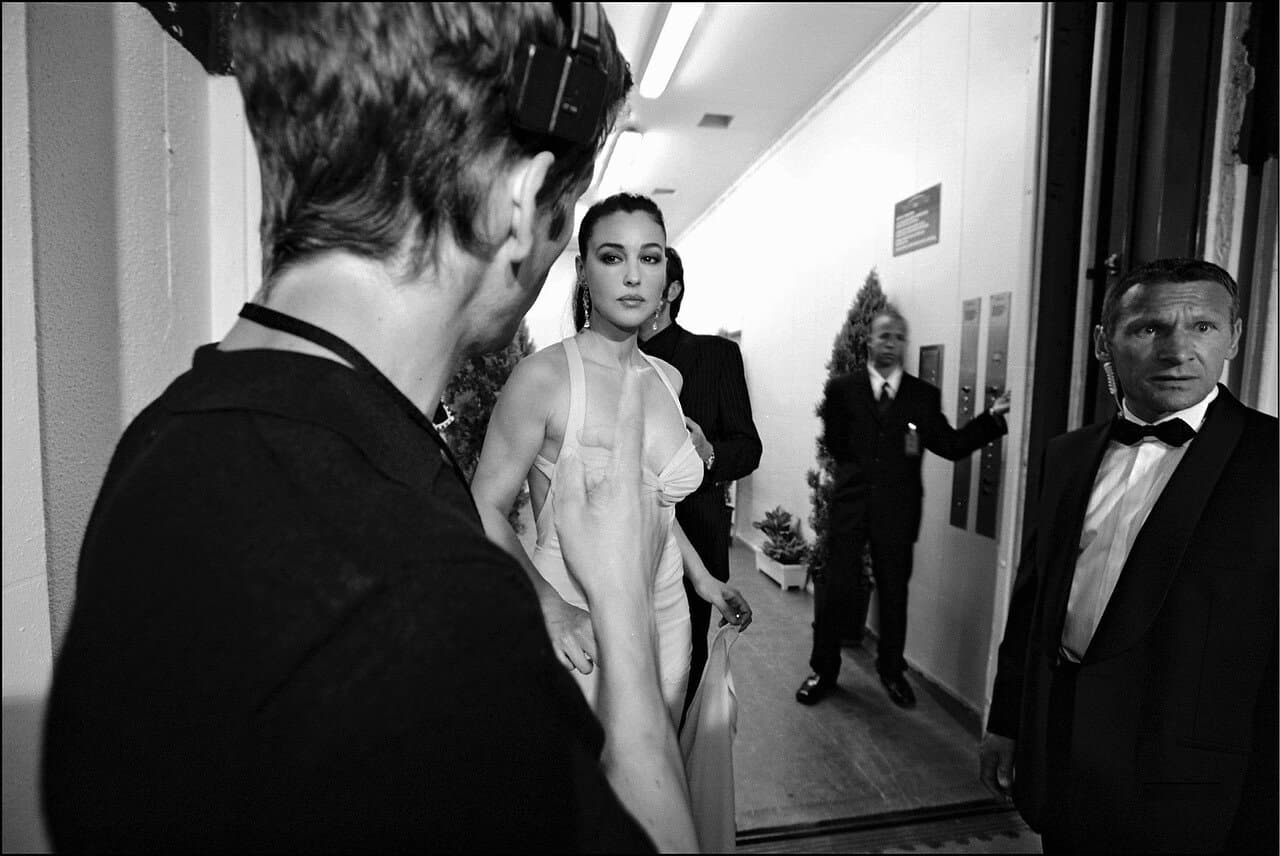 Bellucci steps from backstage toward the ceremony in her floor-length gown.