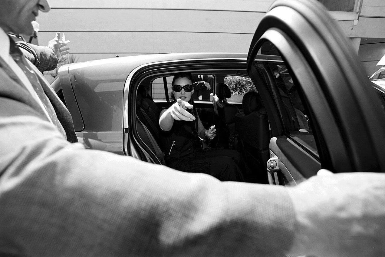 Bellucci is photographed through the open car door during a tightly covered festival arrival.