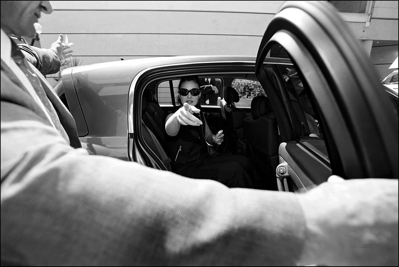 Bellucci is photographed through the open car door during a tightly covered festival arrival.