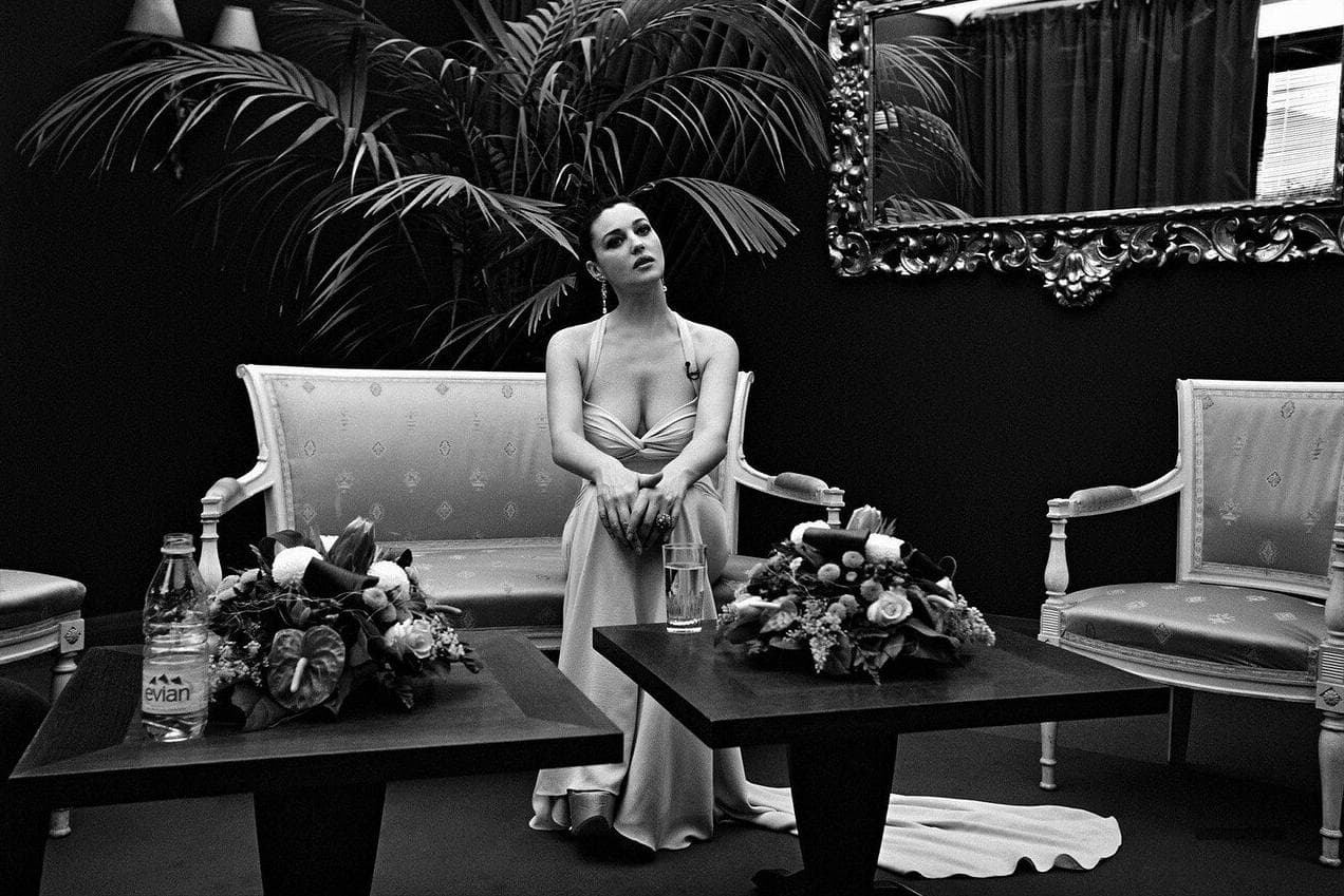 Seated in an elegant Cannes salon, Bellucci prepares to address the camera as the ceremony host.