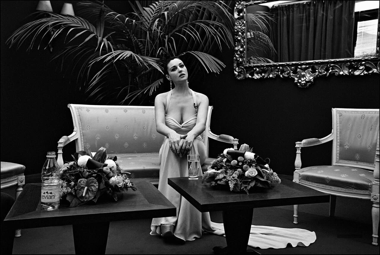 Seated in an elegant Cannes salon, Bellucci prepares to address the camera as the ceremony host.