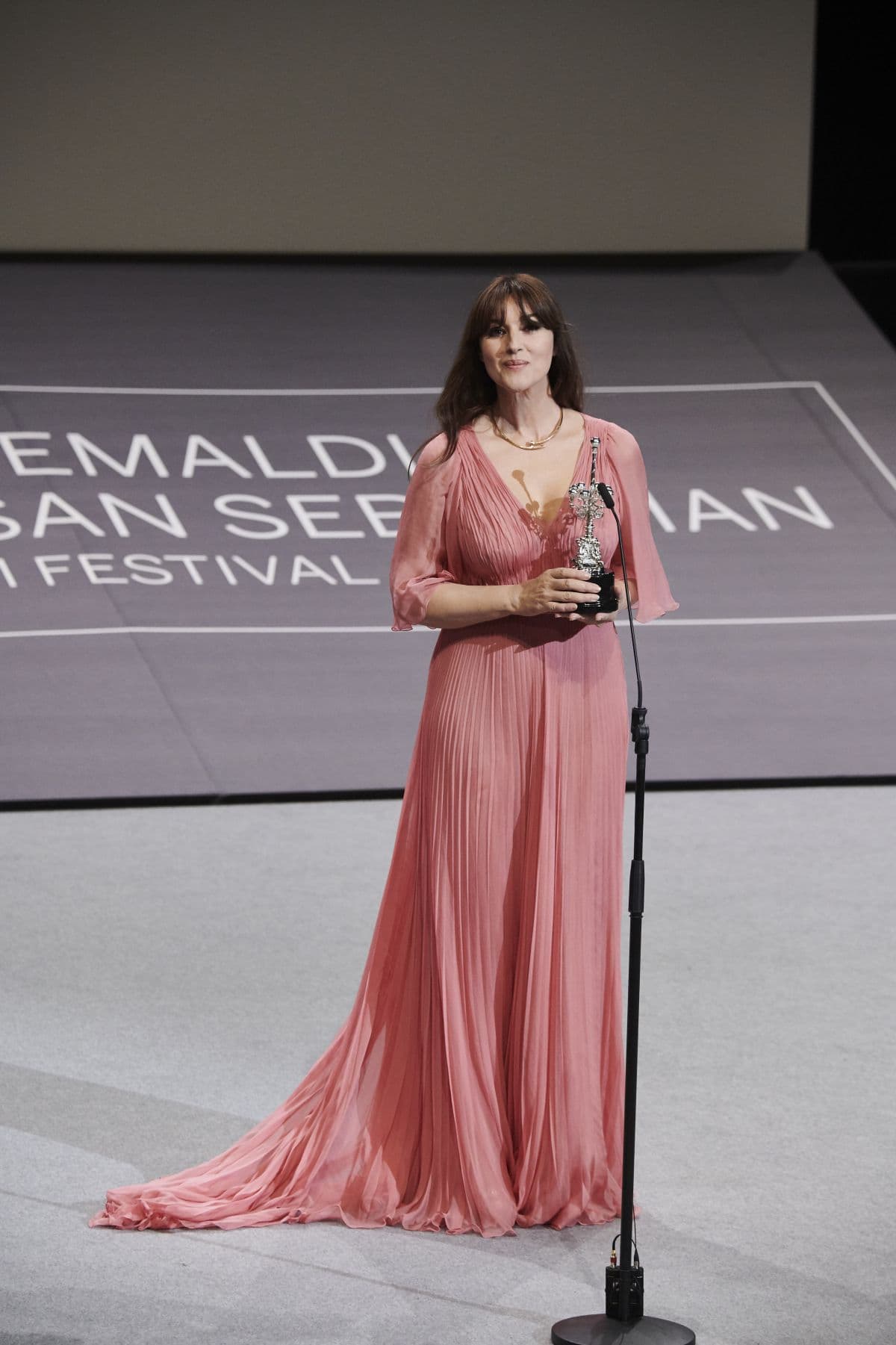 She complemented the pleated number, which featured sheer sleeves and was cinched at the waist with a high band, with an elegant gold necklace... She affectionately greeted actor Jon Malkovich as he presented her award to her
